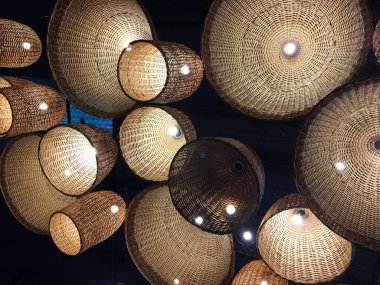 Hasır abajurlu kolye ışığı, köy tarzı. İç mekan için güzel bir dekor. Hassas gölge lambası. Dekoratif tavan hasır lambalı basit bir ev içi. Tahtada asılı fener lambaları.