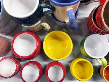 Ahşap arka planda çok renkli kepler ve kaseler. Çömlekçi. Tasarımcı seramik yemekleri. Seramik masa takımı üst görünümü. Modern, boş, derin kaseler. Ev hanımı. Seramik tablo takımı