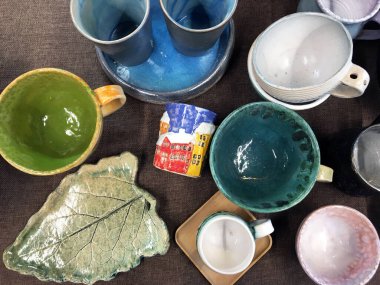 Seramik Tasarımcı Kupaları. Tasarımcı el yapımı yemekler, tabak ve bardaklar şık bir butikte. El boyası seramik şarap şişesi önleyiciler. Sıra dışı seramik ürünler. Eşsiz renkli seramik