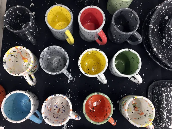 Ceramic cups smeared with paint. Painted ceramic cups. Pottery Shop. Glaze flow hand-painted cup. Paint splash dishes. Multi-colored dishes for children