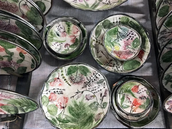 Hand-painted porcelain plates. Oval Shaped Deep Ceramic Designer Plates. Modern ceramic oval plates with flowers draws in the shop. Bowl painted silver outside. Modern handmade ceramic tableware