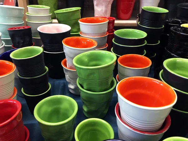 Crumpled Porcelain Cups. Painted colored ceramic crushed plastic cups. Pottery Shop. Glaze flow hand-painted cup. Multi-colored dishes for children.