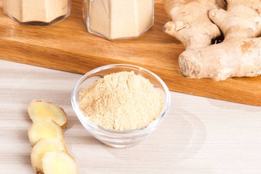 Ahşap arka plan üzerinde kök ve zencefil toz zencefil