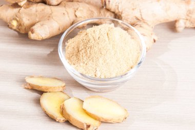 Ahşap arka plan üzerinde kök ve zencefil toz zencefil