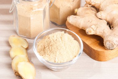 Ahşap arka plan üzerinde kök ve zencefil toz zencefil