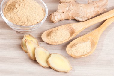 Ahşap arka plan üzerinde kök ve zencefil toz zencefil