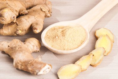 Ahşap arka plan üzerinde kök ve zencefil toz zencefil