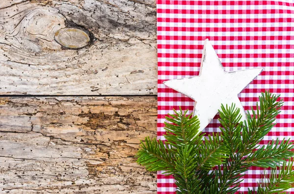 Natural Christmas decoration, white star shape with fir branch on old wood