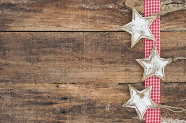 Three Christmas stars frame on rustic wood background, copyspace