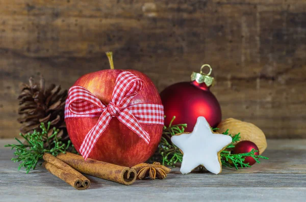 Christmas food composition with red apple fruit, star shaped biscuit, spices and wooden background