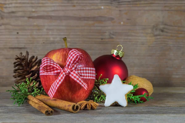 Christmas holiday season still life with food, red apple, sweet star shape biscuit, spices and wood background