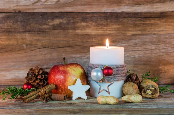Christmas time, ornate candle and food decoration with wood background, copy space