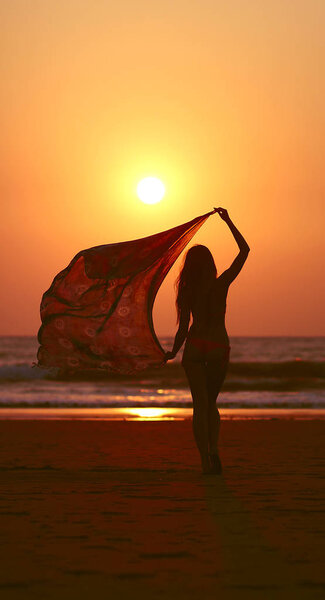 fluttering shawl girl at sunset on the sea