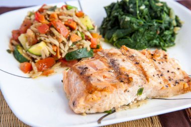 Izgara somon bifteği, pilav ve ıspanak sağlıklı yiyecekler.