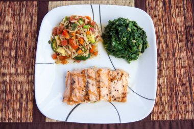 Izgara somon bifteği, pilav ve ıspanak sağlıklı yiyecekler.