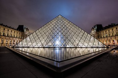 PARIS - 4 Ocak 2013 gecesi Louvre Müzesi ve Piramit. Louvre, Paris 'teki dünyanın en büyük müzelerinden biridir. Tarih öncesi dönemden 19. yüzyıla kadar yaklaşık 35.000 nesne 60.600 metrekarelik bir alanda sergilenmektedir.