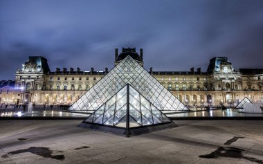 PARIS - 4 Ocak 2013 gecesi Louvre Müzesi ve Piramit. Louvre, Paris 'teki dünyanın en büyük müzelerinden biridir. Tarih öncesi dönemden 19. yüzyıla kadar yaklaşık 35.000 nesne 60.600 metrekarelik bir alanda sergilenmektedir.