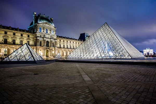 PARIS - 4 Ocak 2013 gecesi Louvre Müzesi ve Piramit. Louvre, Paris 'teki dünyanın en büyük müzelerinden biridir. Tarih öncesi dönemden 19. yüzyıla kadar yaklaşık 35.000 nesne 60.600 metrekarelik bir alanda sergilenmektedir.