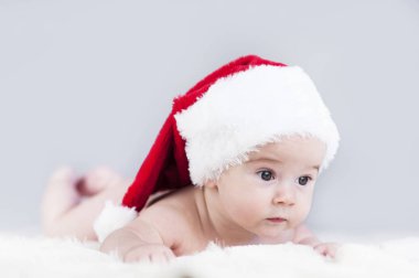 çok güzel parlak duygusal mutlu küçük bebek beyaz ekose üzerinde sürünerek Noel Baba şapkası