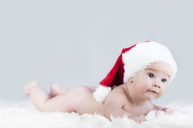 çok güzel parlak duygusal mutlu küçük bebek beyaz ekose üzerinde sürünerek Noel Baba şapkası