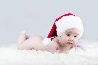 çok güzel parlak duygusal mutlu küçük bebek beyaz ekose üzerinde sürünerek Noel Baba şapkası