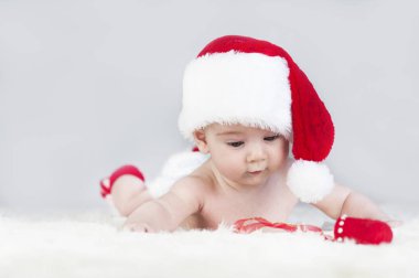 çok güzel parlak duygusal mutlu küçük bebek beyaz ekose üzerinde sürünerek Noel Baba şapkası
