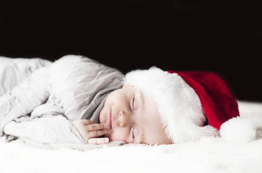 çok güzel parlak mutlu küçük bebek beyaz ekose gri kumaş sarılmış uyku Noel Baba şapkası