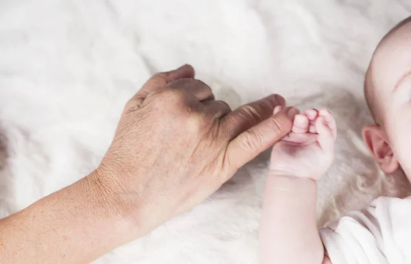 As gerações diferença nas mãos de, avós mão com alça criança — Fotografia de Stock