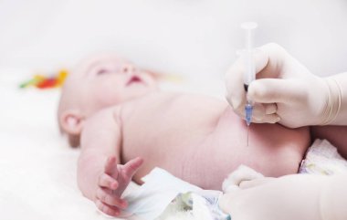 Çok küçük bir çocuk, Bebek, doktor ofisinde yalan söylüyor ve doktor iğne yapar.
