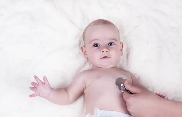 Uma Criança Muito Pequena Bebê Deita Consultório Médico Médico Ouve — Fotografia de Stock