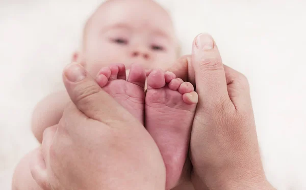 Parent holds gentle little feet in a newborn baby