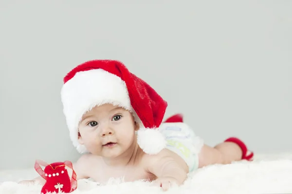 Happy newborn girl in santa hat. New Year and Christmas