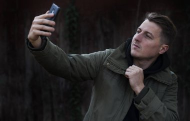 Selfie alma ve jest Yaşasın beyaz arka plan üzerinde gösterilen mutlu bir casual adam portresi kapatın