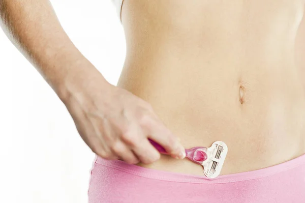 Genç bir kız bir bikini beyaz bir arka plan üzerinde tıraş oluyor. Nazik, sıkılır cilt tahriş etmeden.