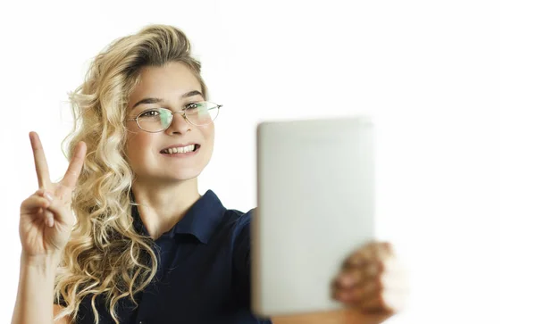 Happy business woman standing with table computer over white background. Wear a blue shirt and glasses. Conversation with gadget