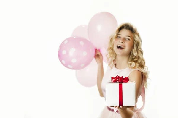 Menina bonita nova com um presente branco com um arco vermelho e bolas nas mãos se alegra com um fundo branco isolado. Conceito de dia dos namorados . — Fotografia de Stock