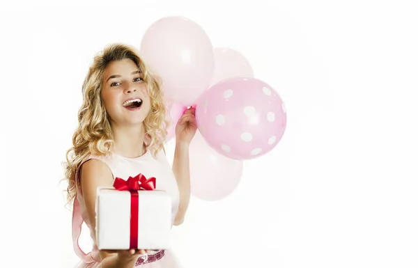 Joven chica hermosa con un regalo blanco con un lazo rojo y bolas en las manos se regocija sobre un fondo blanco aislado. Concepto de San Valentín . — Foto de Stock