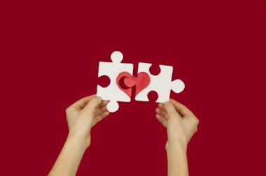 Sevgi dolu bir çift elinde kırmızı bir kalp ile bulmaca. Sevgililer günü kavramı. Arka plan üzerinde kırmızı bir izole