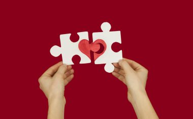 Sevgi dolu bir çift elinde kırmızı bir kalp ile bulmaca. Sevgililer günü kavramı. Arka plan üzerinde kırmızı bir izole