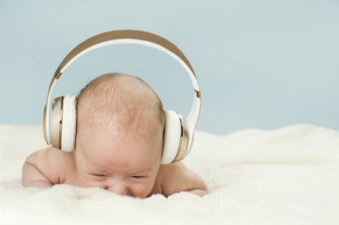 büyük kulaklıklar üzerinde mavi arka plan izole müzik dinlemek güzel yeni doğan bebek
