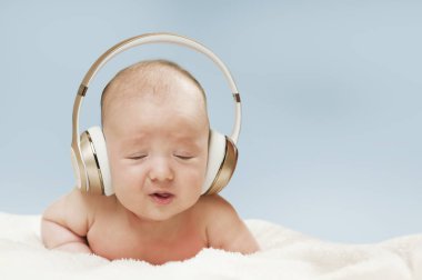 büyük kulaklıklar üzerinde mavi arka plan izole müzik dinlemek güzel yeni doğan bebek