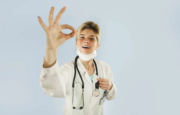 Mladý Lékař Dívka Ukazuje Palcem Modrém Pozadí Izolované Koncept Medicína — Stock fotografie
