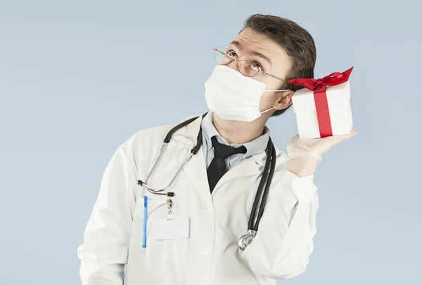 genç doktor öğrenci bir izole mavi background.concept ilaç ve sağlık, tatil ve hediyeler onun elinde bir hediye ile