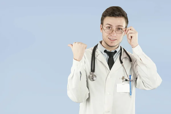Νεαρά Αρσενικά Γιατρός Ιατρικός Λειτουργός Δείχνει Κενό Χώρο Στην Απομονωμένη — Φωτογραφία Αρχείου
