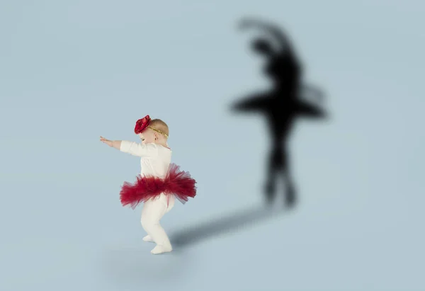 Girl dreaming about dancing ballet. Childhood and dream concept. Conceptual image with shadow of ballerina on the studio wall — Stock Photo, Image