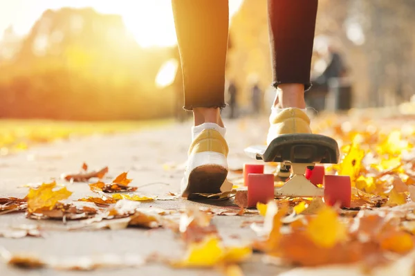 movement to sunset on the road on a skateboard of a young girl\'s legs. concept of sport