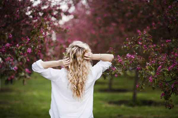 Ritratti di una bellissima ragazza nel parco primaverile con alberi in fiore — Foto Stock