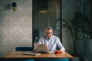 yas rutini. kafe barda kahve molası gazete okuma işadamı