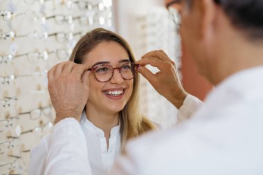 Bu sana en çok yakışan.optik mağazada gözlük seçen kadın.