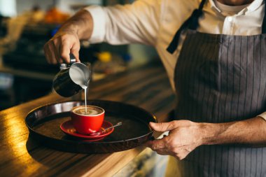 Barmen kafede kahve süt dökme